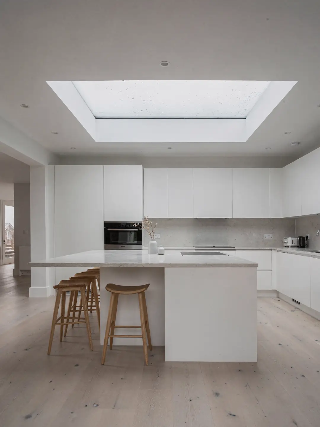Bright loft bedroom with a double glazed roof window lighting a pale wall and a made bed