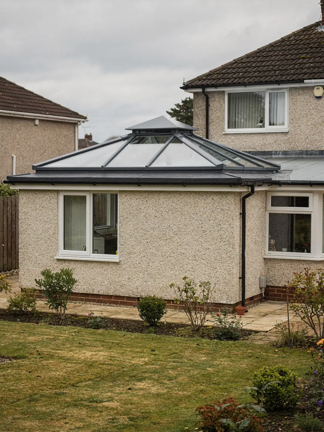 Roof lantern on the flat roof of a single-storey extension at the back of a pebble-dashed semi