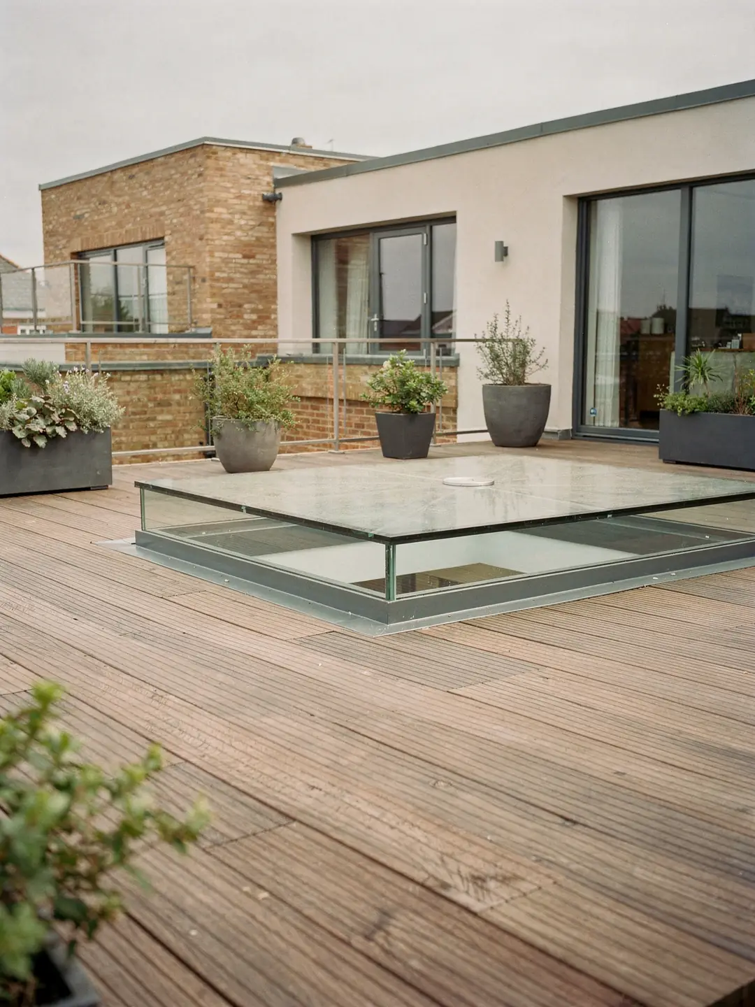 Walk-on rooflight set into a paved rear terrace, with the room below visible through the glass