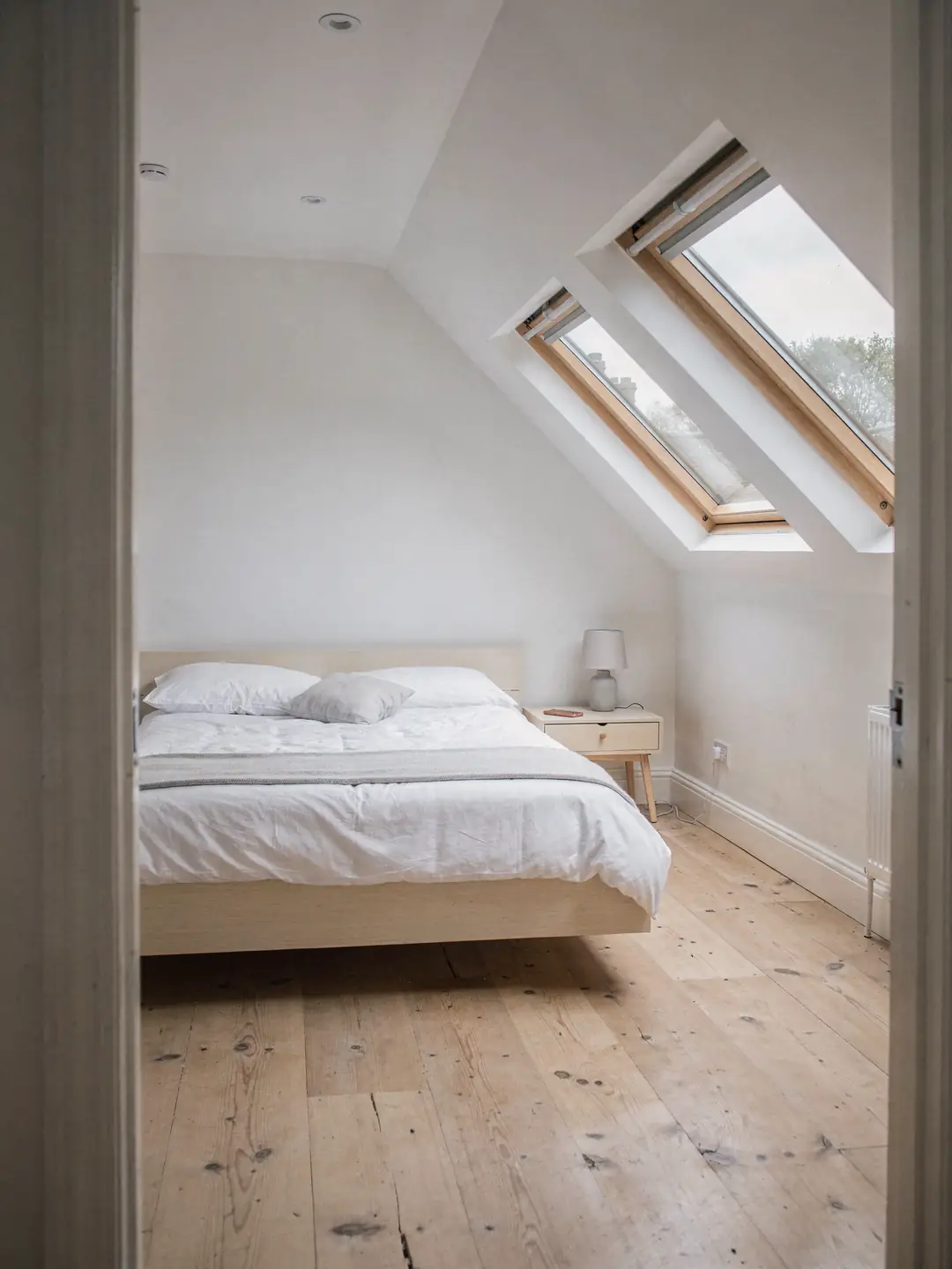 Roof window set into a tiled slope above a loft bedroom in a 1930s semi