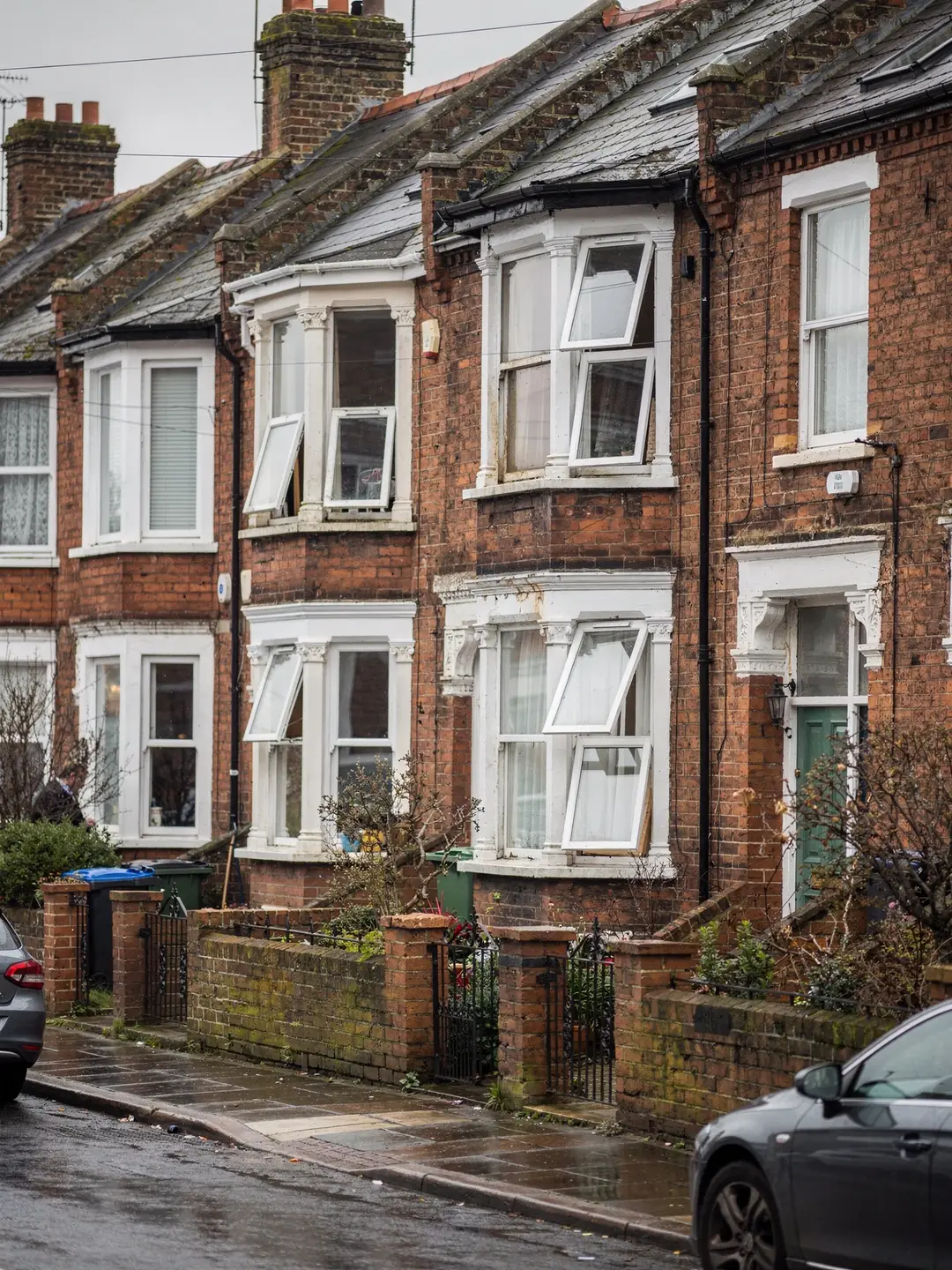 A terrace of Edwardian brick houses with slate roofs and a roof window in one slope