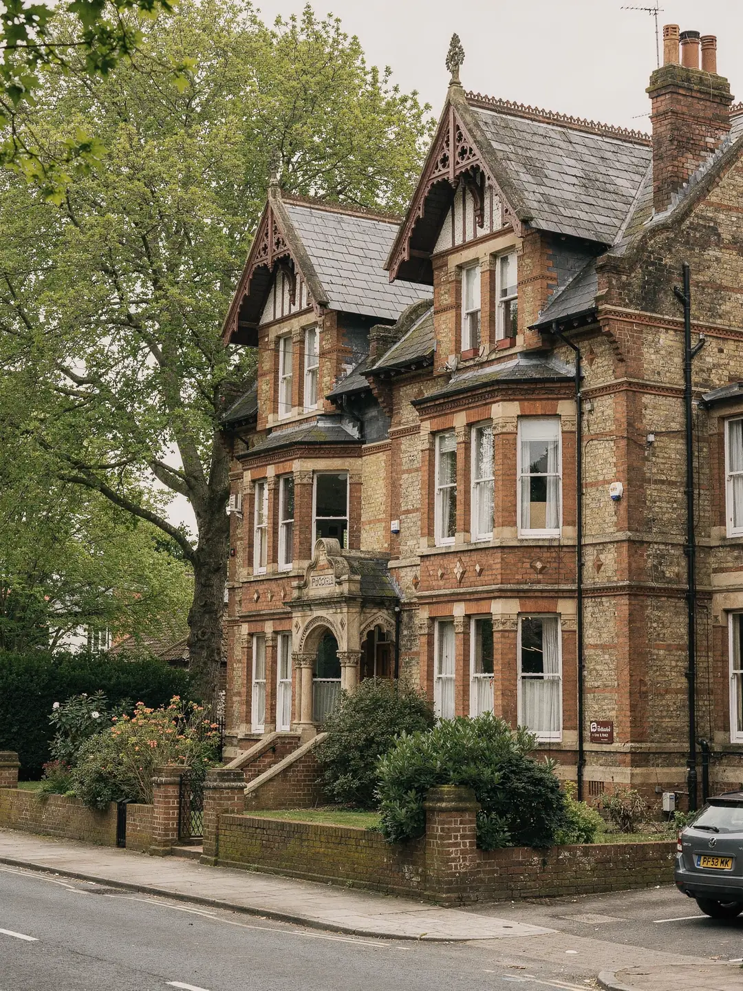 A large brick villa with a pitched slate roof and a roof window in the front slope