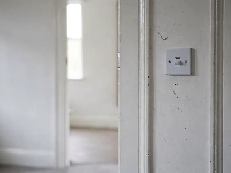 Wall-mounted switch beside a doorway