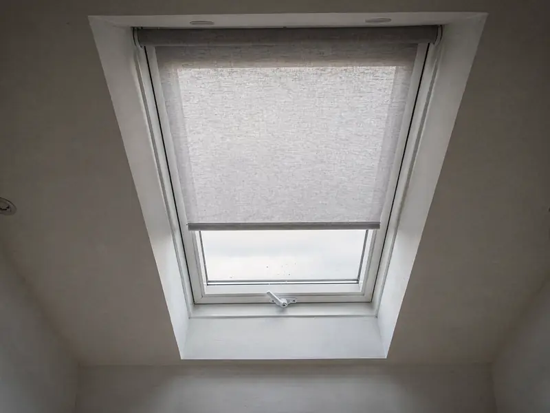 Roof window with a fabric blind half drawn