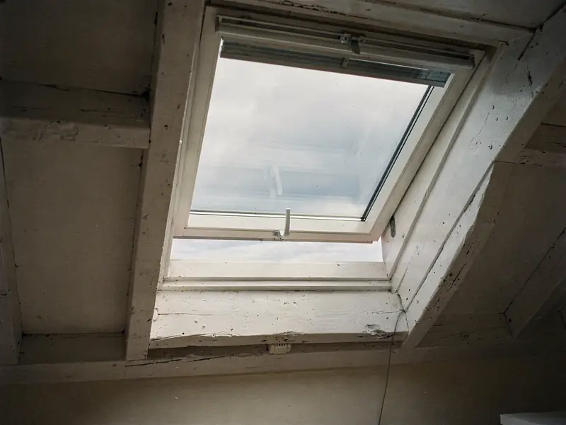 Top-hung roof window lifted open at the bottom edge